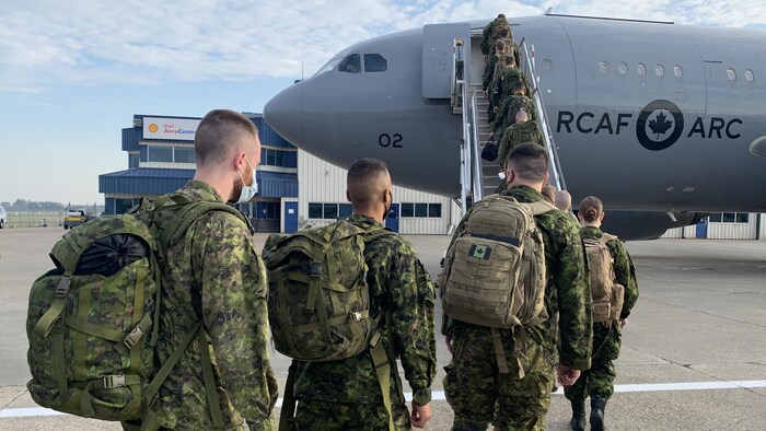 جنود كنديون يصعدون إلى طائرة نقل عسكرية.