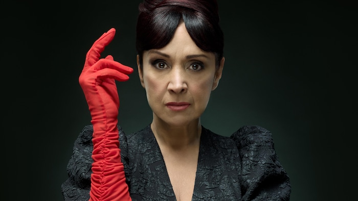 Une femme avec des gants rouges qui pose.