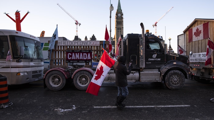 Des camionneurs participent à un convoi traversant le pays pour protester contre les mesures sanitaires pour freiner la propagation de la COVID-19 sont stationnés sur la rue Wellington devant la Colline du Parlement à Ottawa, le vendredi 28 janvier 2022.