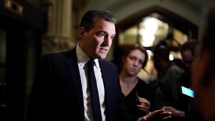 Evan Solomon questionné par des journalistes. 