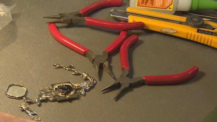 Des outils et une montre ouverte sont disposés sur une table.