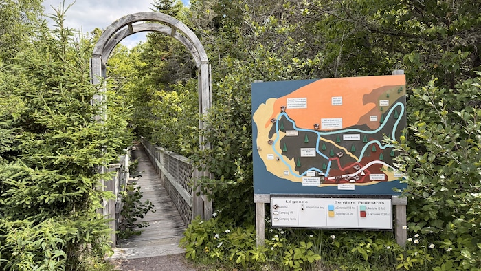 Un bout d'un sentier avec une arche et une carte.