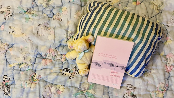 Le livre « Ce qui se passe en moi aura lieu de toute façon », de Julie Benoît, déposé sur un oreiller et un lit.