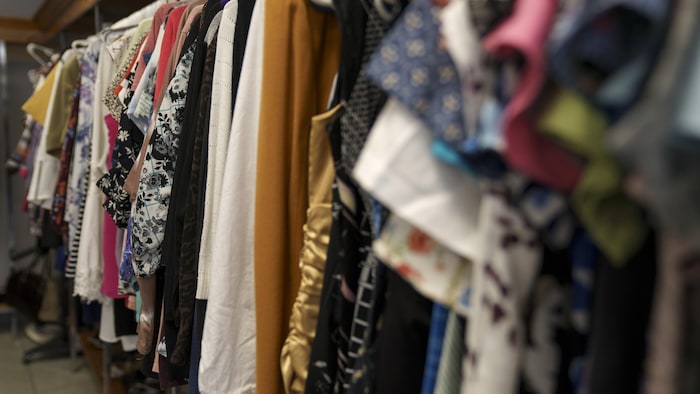 Des rayons de vêtements dans une friperie.