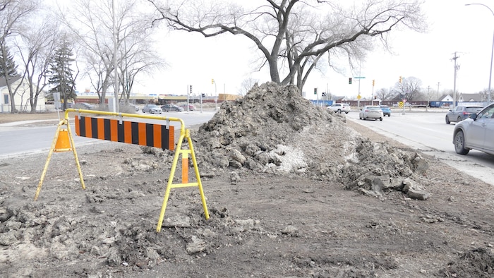 Une montagne de boue et une pancarte au milieu du boulevard Provencher.