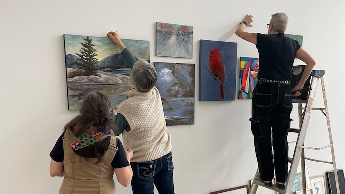 Trois artistes installent des œuvres artistiques au mur de la Galerie du Nouvel-Ontario.