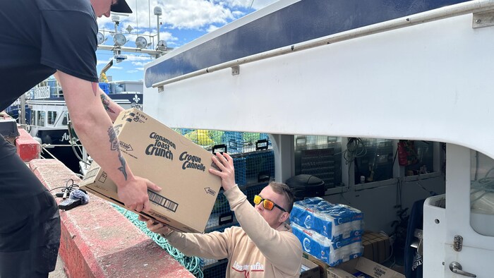 Mathieu Langlois à gauche et le capitaine du Steady Rollin Brandon Leblanc à bord du bateau