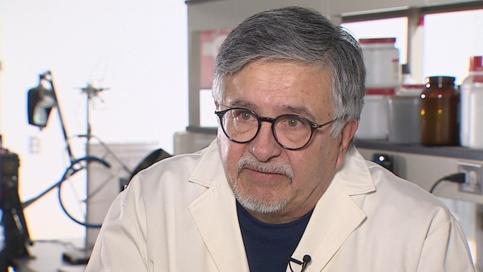 Pedro Pereira-Almao porte une blouse blanche. Il répond à des questions d'un journaliste dans le laboratoire de son entreprise Nanos Tech à Calgary.