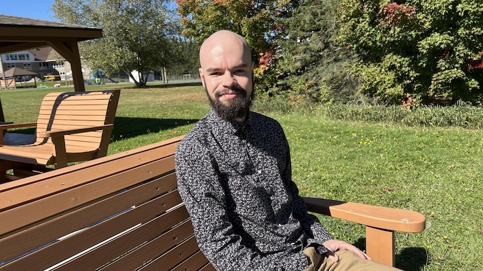 Un homme assis sur un banc.