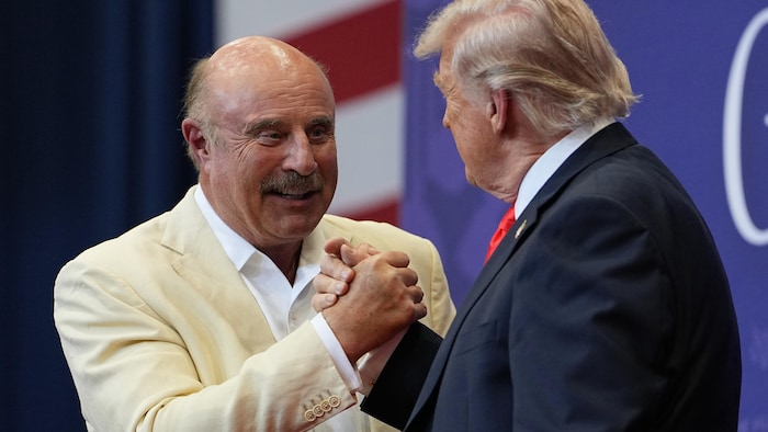 Phil McGraw serre la main de Donald Trump lors d'un événement en mai 2026.