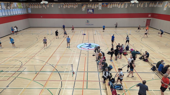 Des joueurs de pickleball dans un gymnase.