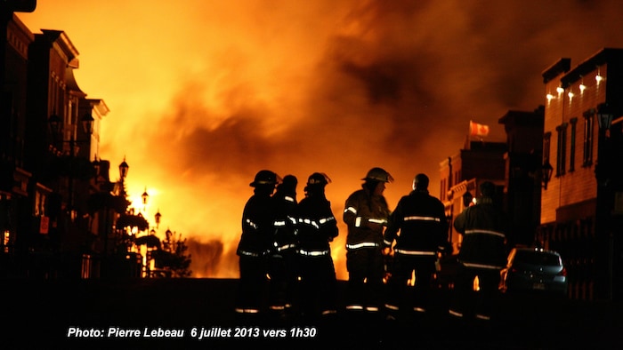 Des pompiers dans un Lac-Mégantic en flammes. 