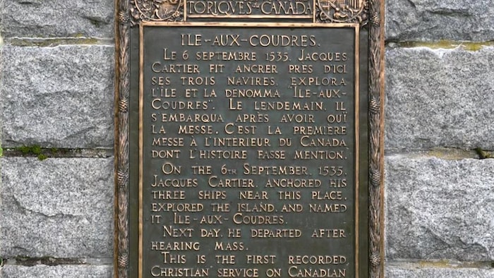 La plaque commémorative du passage de Jacques Cartier, en métal, installée sur des pierres.