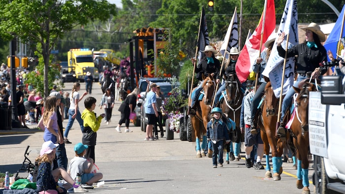 Des chars allégoriques et des personnes à cheval défilent dans une rue en saluant la foule, le 28 juin 2024.