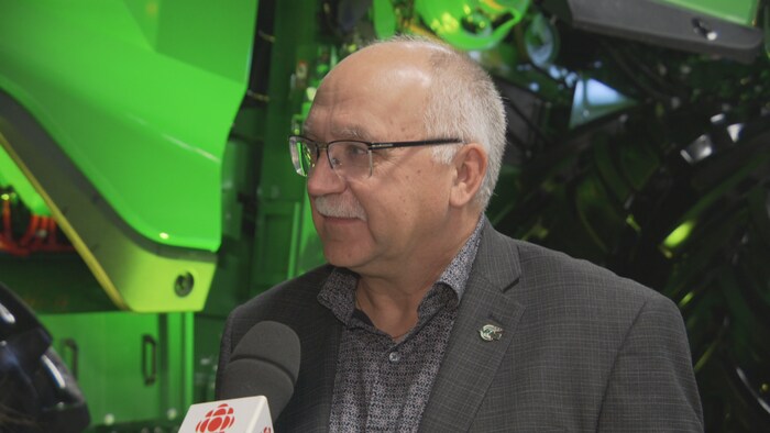 Bill Prybylski se tient devant les micros des journalistes en conférence de presse.