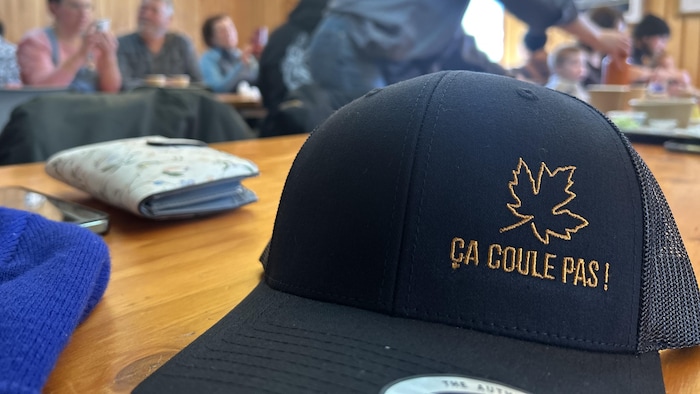 Une casquette sur laquelle il est inscrit « ça coule pas ».