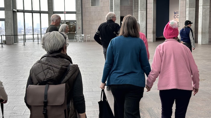 Des personnes qui marchent dans une salle du Musée des beaux-arts du Canada.