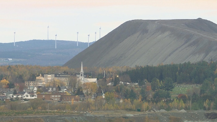 Un village surplombé par une montagne de résidus.