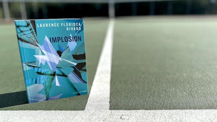 Le livre «Implosion» de Laurence Florisca Rivard déposé sur un terrain de tennis.