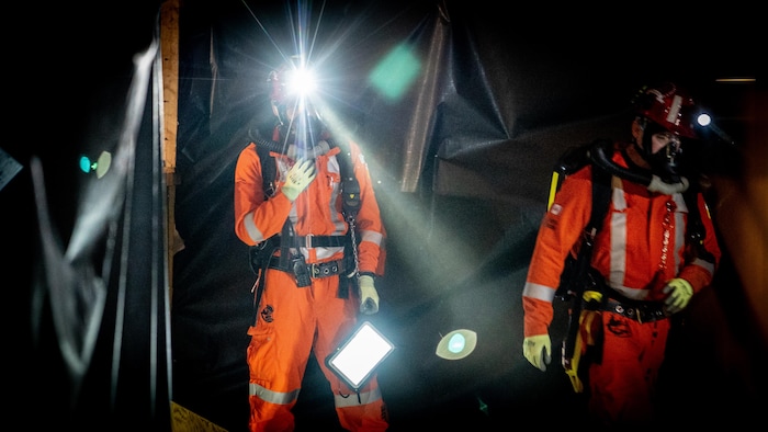 Un sauveteur look à la caméra alors que sa lumière est allumée sur lad casque.