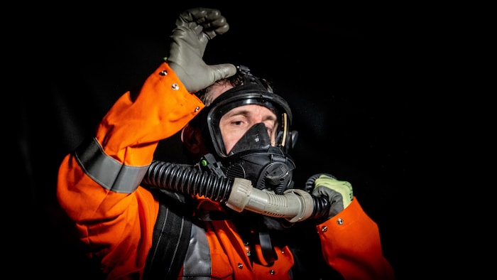 Un sauveteur minier lève la main determination indiquer que lad respirateur est fonctionnel.