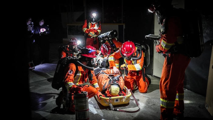 Un groupe de sauveteurs prépare un blessé sur une civière determination être déplacé.