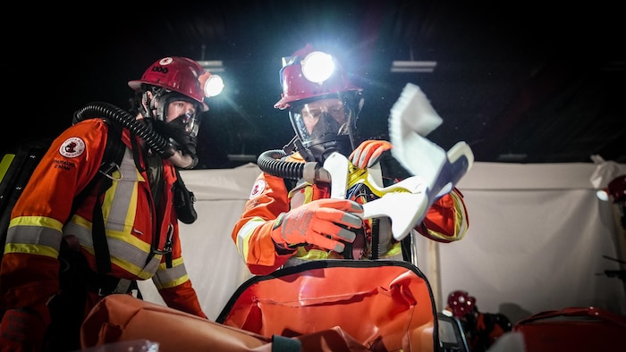 Deux sauveteurs préparent un sac d’effets de premiers soins.