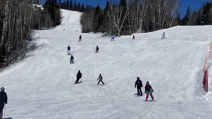 Des gens qui descendent une pente de ski.