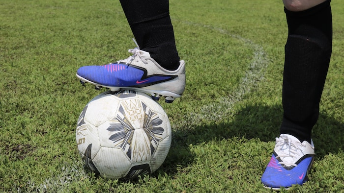 Un pied sur un ballon de soccer.