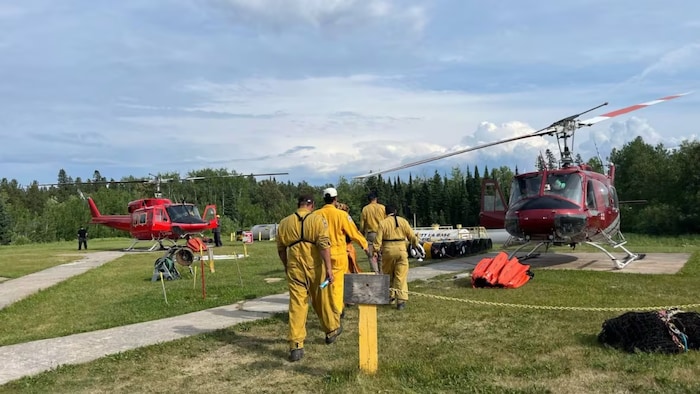 Des pompiers marchent vers des hélicoptères