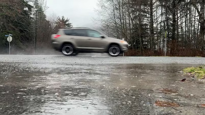 Une voiture roule sur une rue avec beaucoup de pluie, à Squamish.