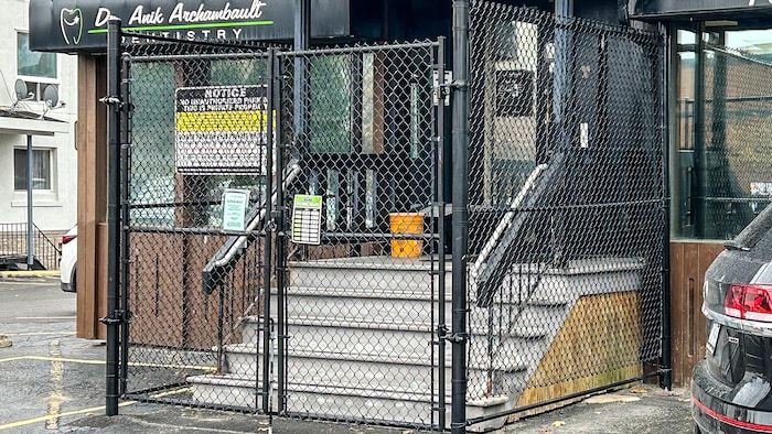 Une clôture ceinture les escaliers d'un cabinet de dentiste situé au centre-ville du Grand Sudbury.