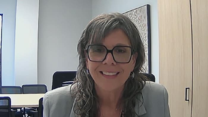 Suzie Lucas sourie à la caméra lors d'une entrevue en visioconférence.