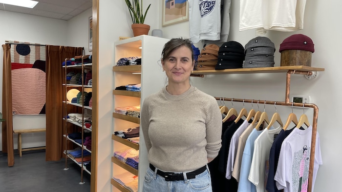 Femme debout devant des étagères de linge.