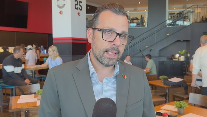 Un dirigeant répond à des questions de journalistes.