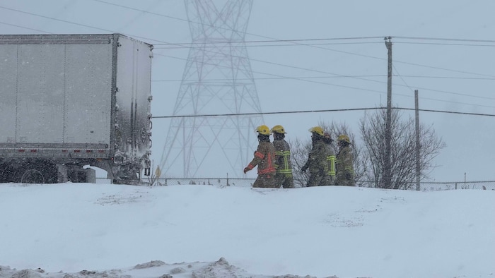 Des pompiers marchent parmi les débris d'un accident.