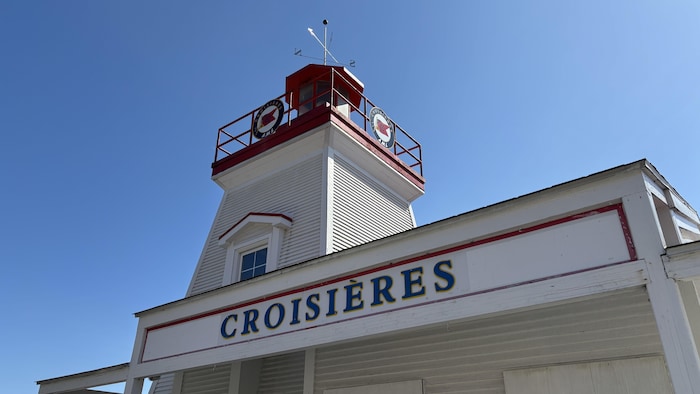 Un phare avec une affiche indiquant croisières.