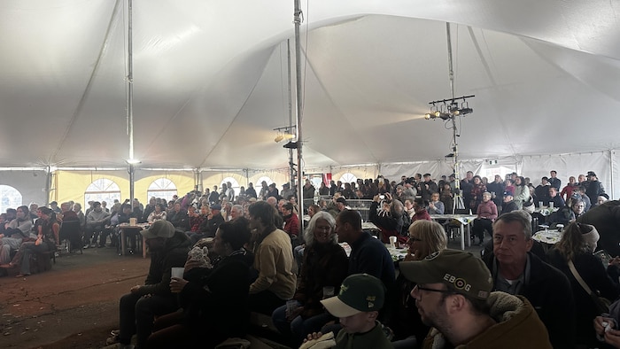 Une foule sous une grande tente à un festival.