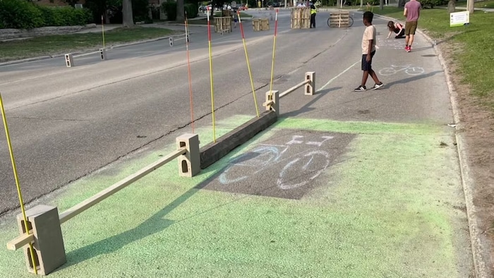 Une piste cyclable bricolée installée sur une route.