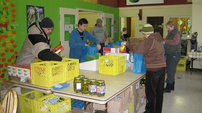 Personas toman alimentos donados en el Banco de Alimentos de Yukón.