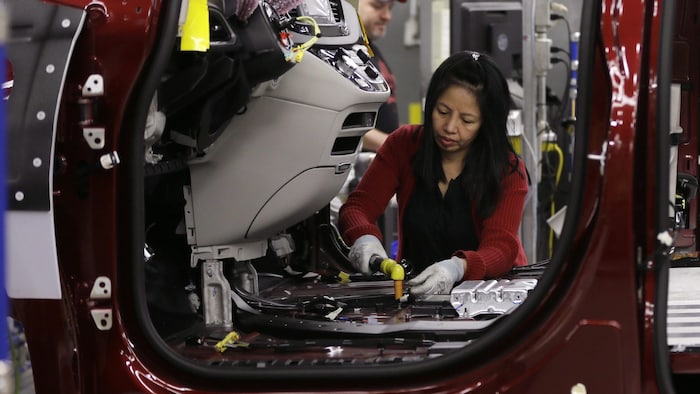 An employee at the Stellantis Windsor Assembly Plant in southwestern Ontario works on the line, assembling a vehicle for the region's largest employer. Auto industry interests are closely watching Tuesday's U.S. election, the results of which could impact the industry on both sides of the border. 