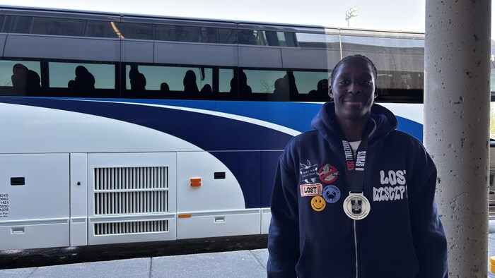 Un jeune homme qui sourit avec une médaille au cou.