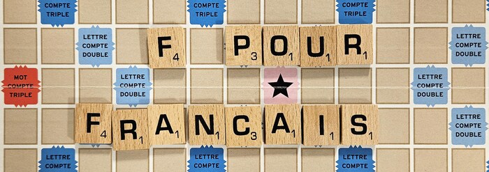 Une planche de Scrabble sur laquelle sont placées des lettres pour former la mention : « F pour Français ».