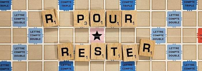 Une planche de Scrabble sur laquelle sont placées des lettres pour former la mention : « R pour Rester ».