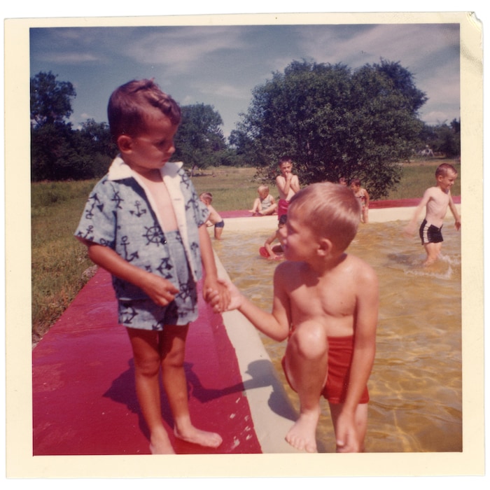 Une photo d'archives de deux jeunes garçons sur le bord d'une pataugeoire. D'autres enfants sont aussi visibles en arrière-plan.