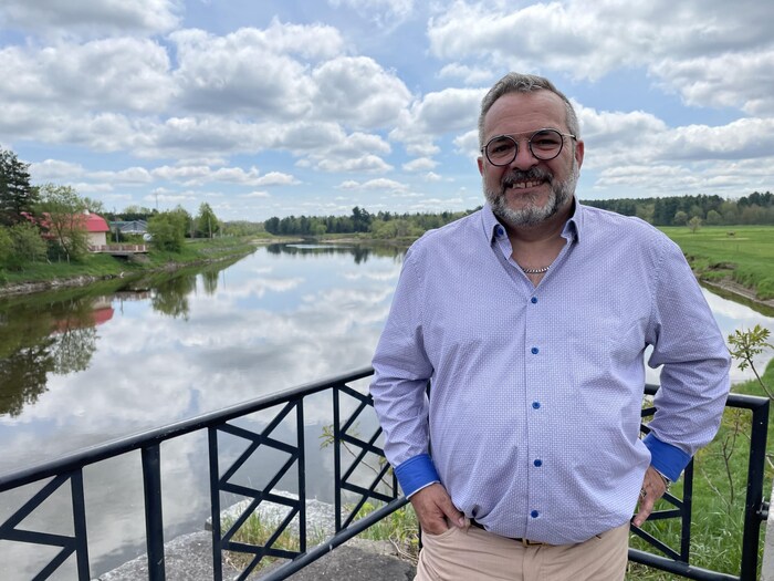 Il se tient sur le bord de l'eau.