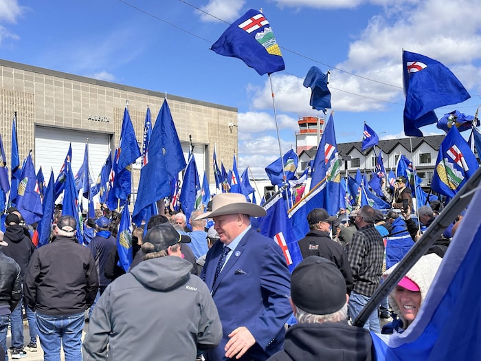 Groupe de gens tenant des drapeaux de l'Alberta. 4 mai 2026.