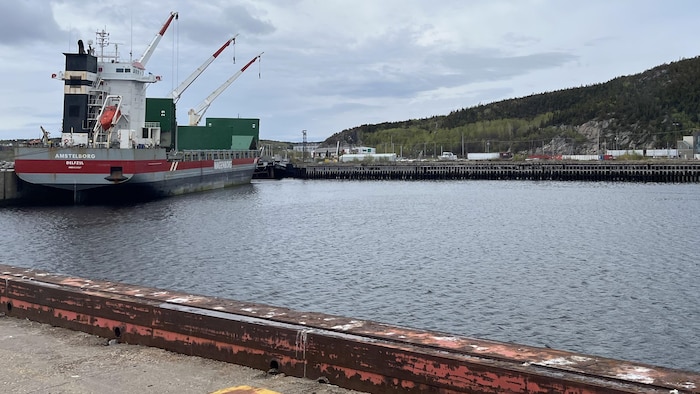Un navire accosté au port, près du quai, lors d'une journée nuageuse.