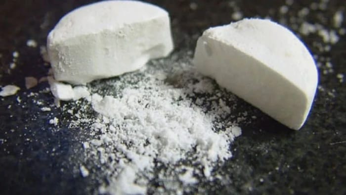 Une pilule de fentanyl coupée en deux.