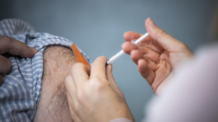 Un travailleur essentiel reçoit une dose d'un vaccin contre la COVID-19 au Vancouver General Hospital, le 4 mars 2021.